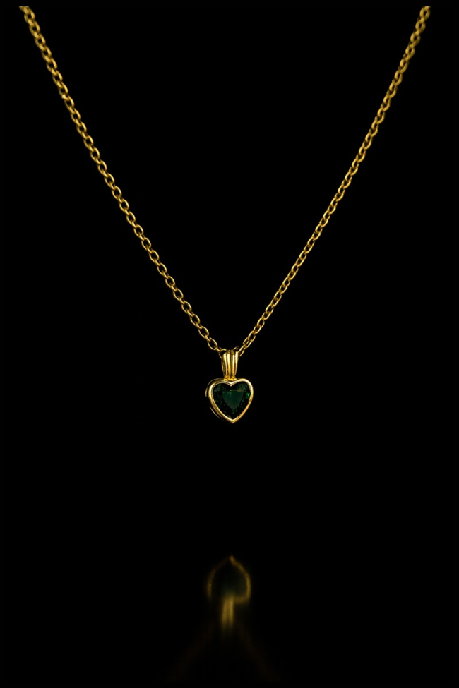 Κομψό μενταγιόν Emerald Serenity Heart σε σχήμα καρδιάς με πράσινη πέτρα και περίτεχνο δέσιμο, ιδανικό για να προσφέρει μια πινελιά πολυτέλειας και χρωματικής έντασης στις εμφανίσεις σας.